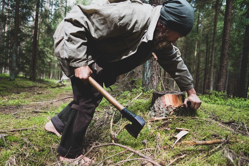 Florian Köhler arbeitet barfuß mit einer Axt im Wald – Erdung und Fokus in der Wildnispädagogik
