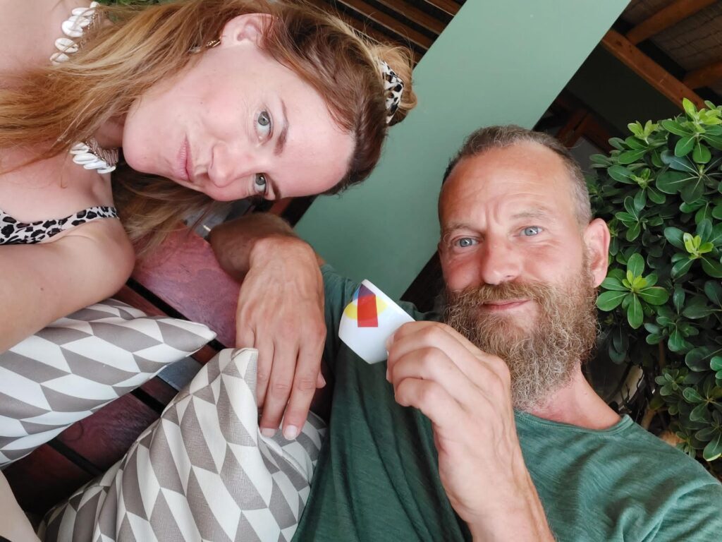 Ein Mann mit Bart hält eine Espressotasse, neben ihm sitzt eine Frau, während einer Pause beim Retreat auf Korfu.
